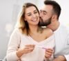 Uma casal comemorando pela gravidez diagnosticada no teste.