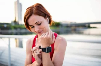 Mulher se preparando para uma corrida com smartwatch.