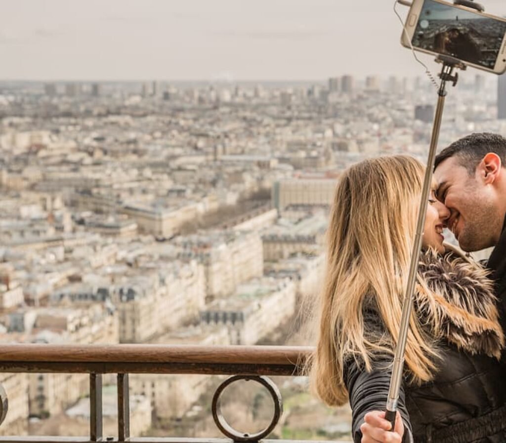 Um casal em cima de um prédio tirando selfie.