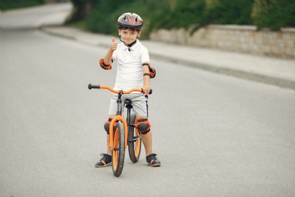 Menino em uma bicicleta laranja dando jóia.