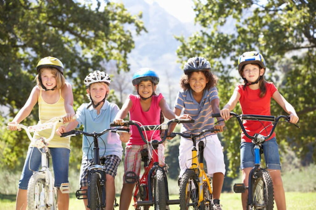 Grupo de cinco crianças de bicicleta.