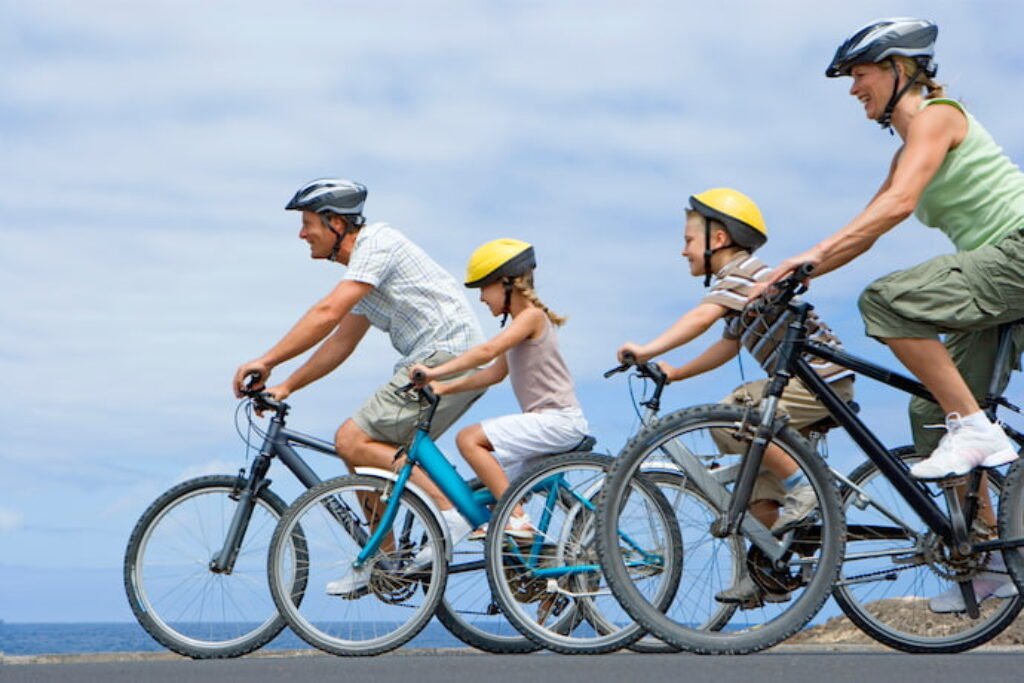 Família de cinco pessoas andando de bicicleta.