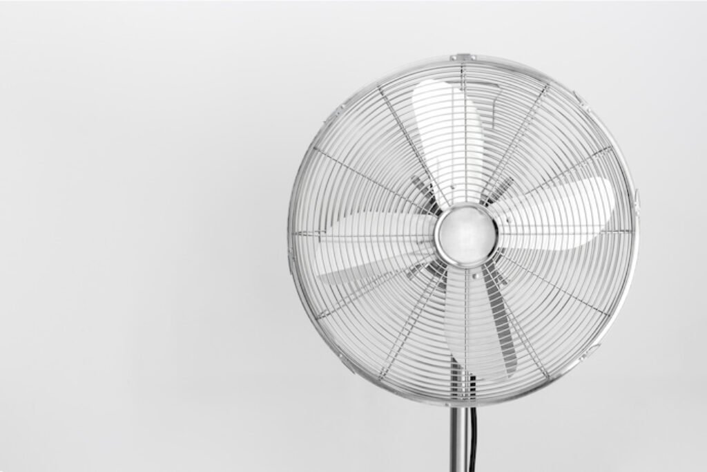 Ventilador desligado em um fundo cinza.