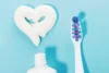 Pasta de dente formando um coração ao lado de uma escova.