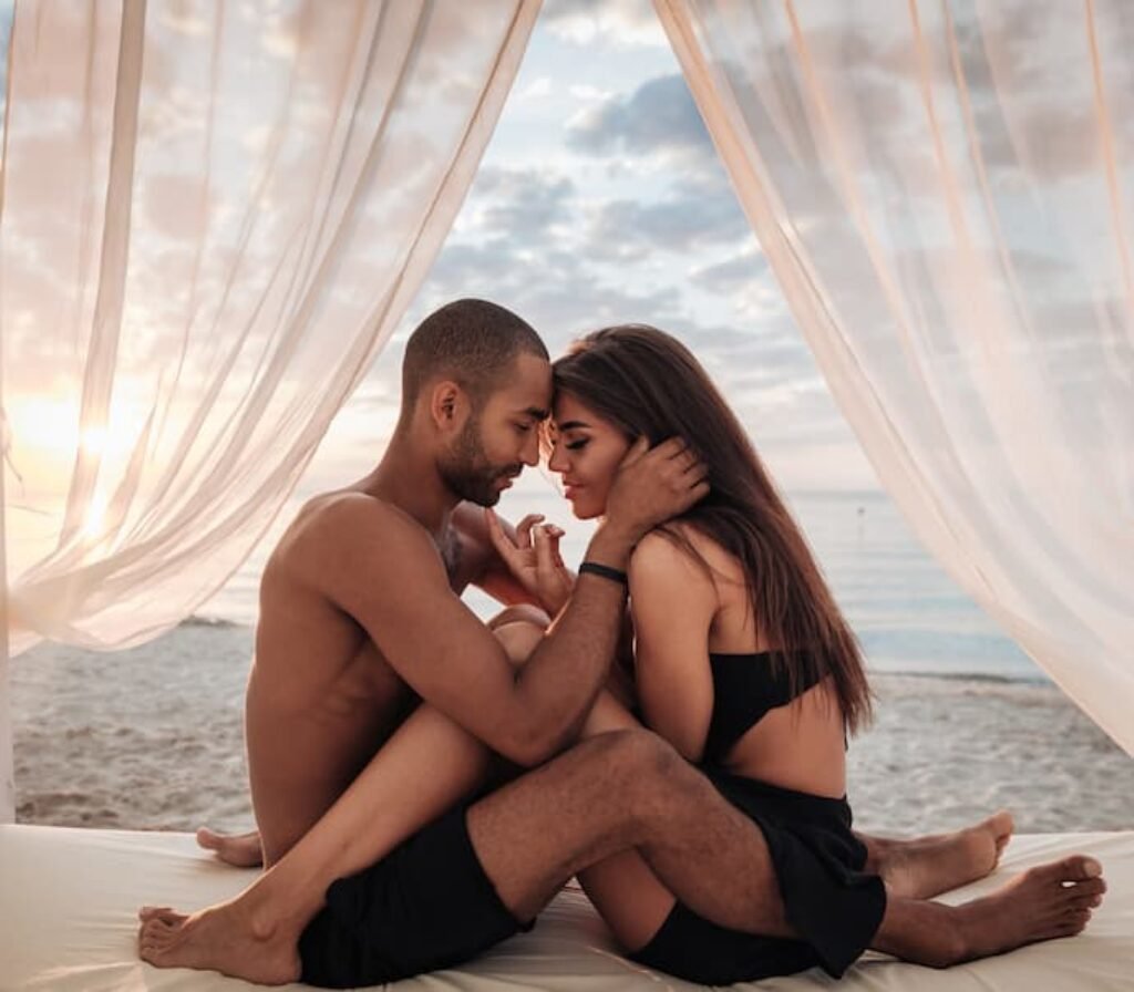Um casal sentado na cama com uma tenda.