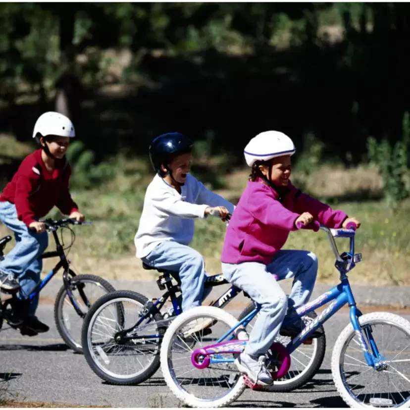 Três crianças andando de bicicleta.