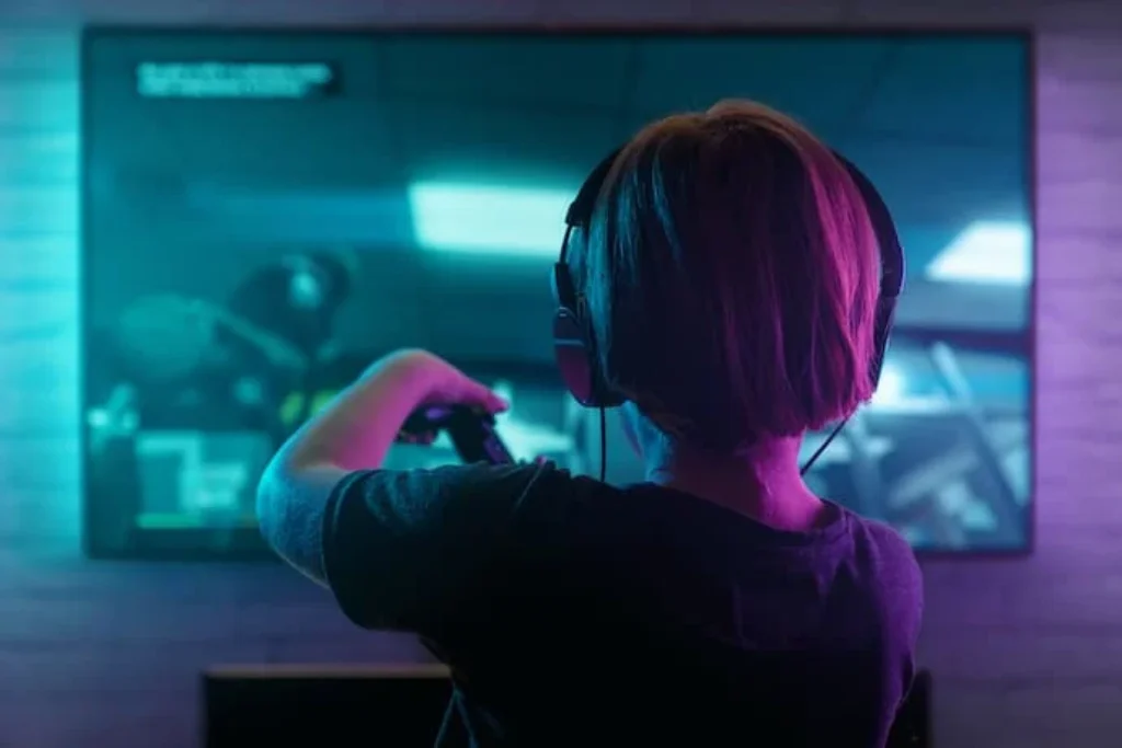 Criança jogando Ps5 na frente da TV.