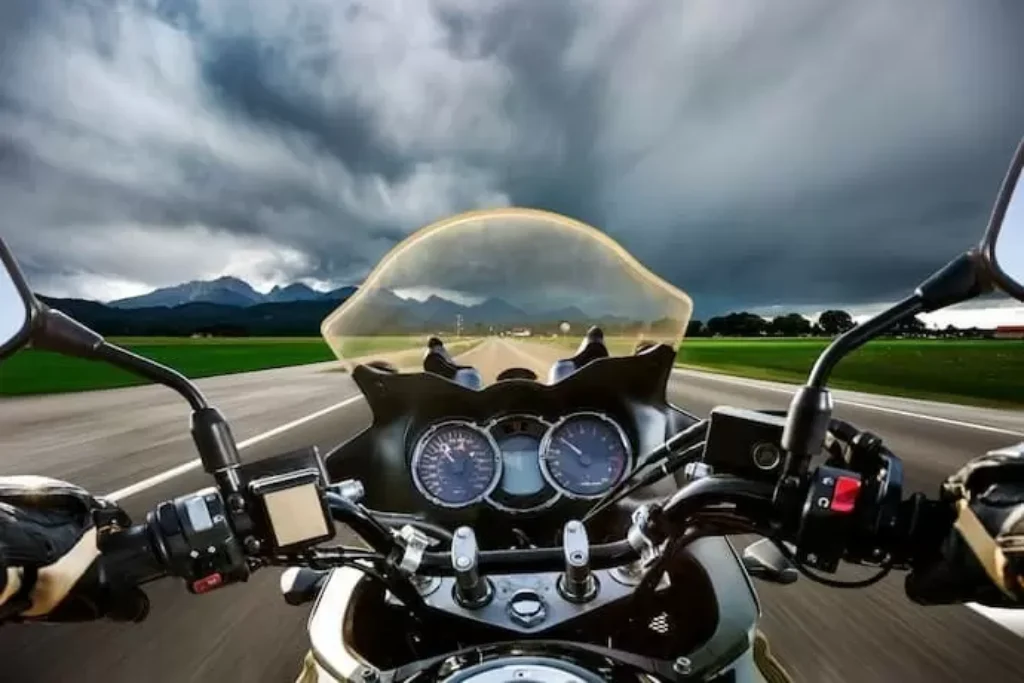 Um motociclista em uma pista com o céu nublado.