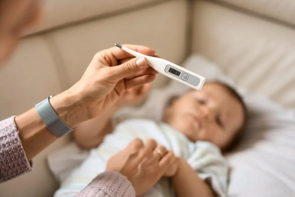 Uma pessoa verifica a temperatura de um bebê em um termômetro.