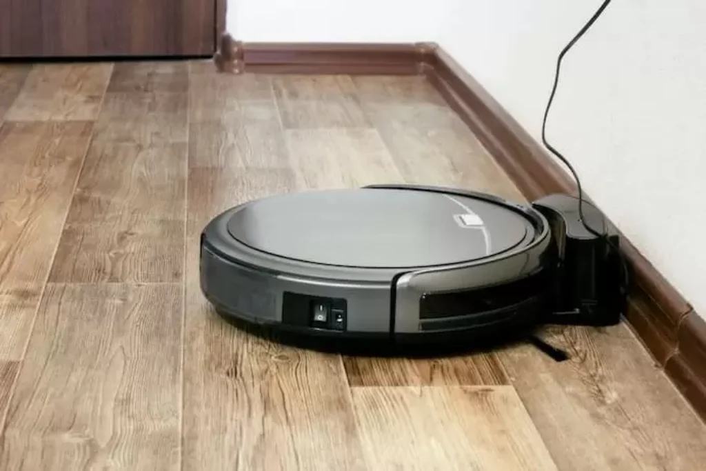 Um robô aspirador conectado na tomada e carregando a energia.