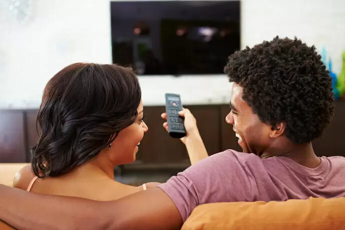 Casal assistindo TV.