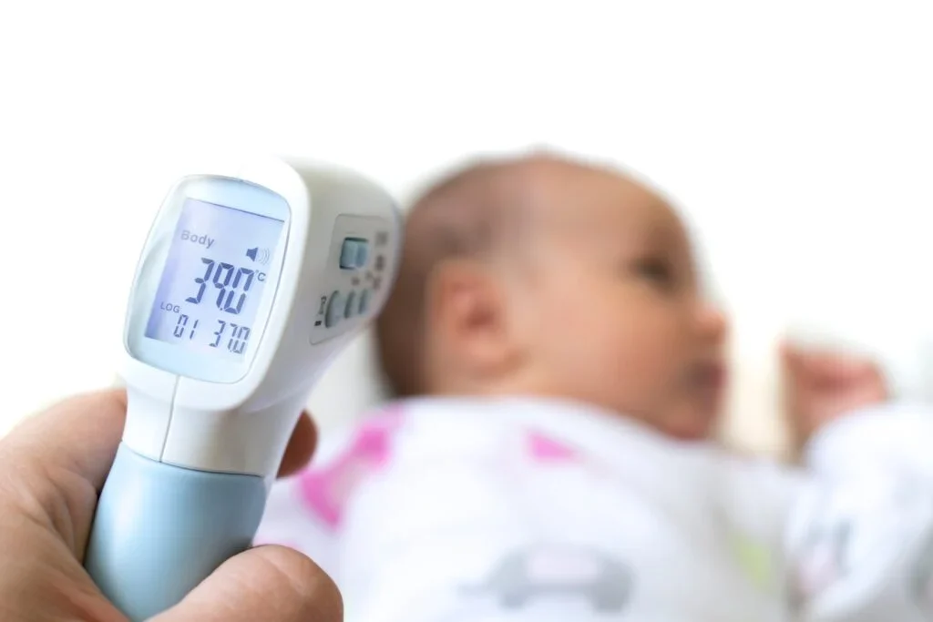 Um termômetro digital infravermelho mede a temperatura de um bebê.