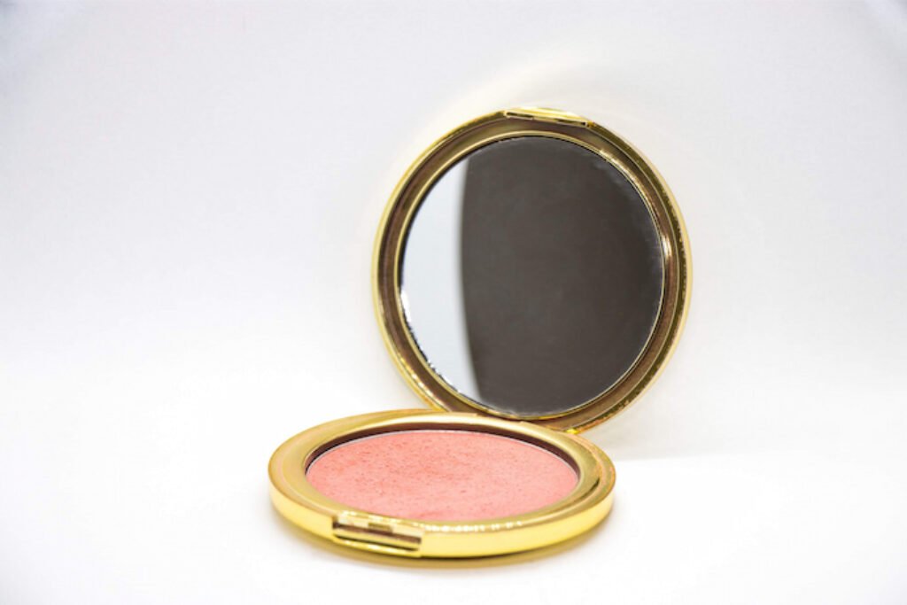 Blush com espelho em sua estrutura em um fundo branco.