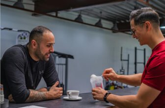 Dois homens conversando enquanto um deles prepara whey.