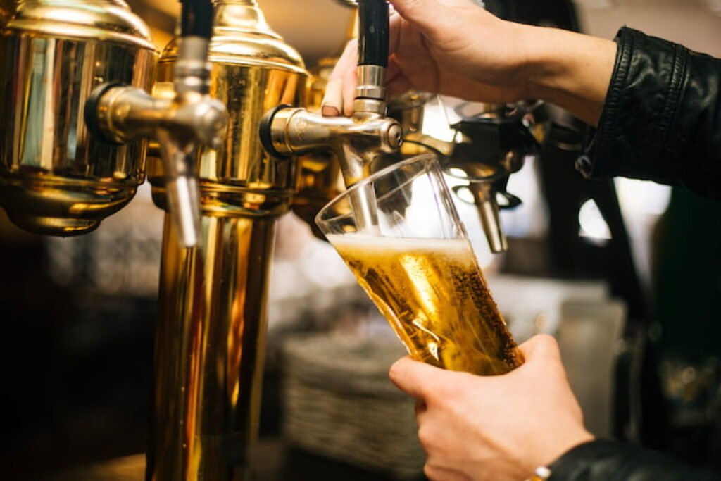 Pessoa colocando chopp diretamente da máquina.