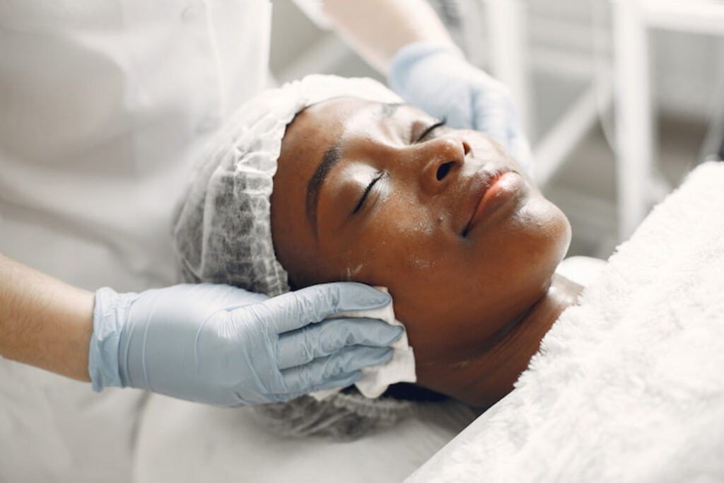 Mulher recebendo skin care no rosto.