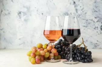Duas taças de vinho ao lado de uvas.