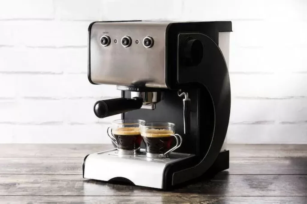 Duas xícaras cheiras de café em uma cafeteira elétrica de café expresso.