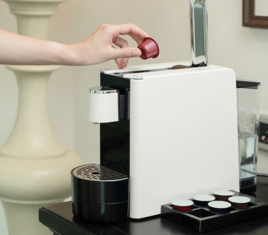 Uma pessoa colocando uma cápsula na melhor cafeteira Dolce Gusto.