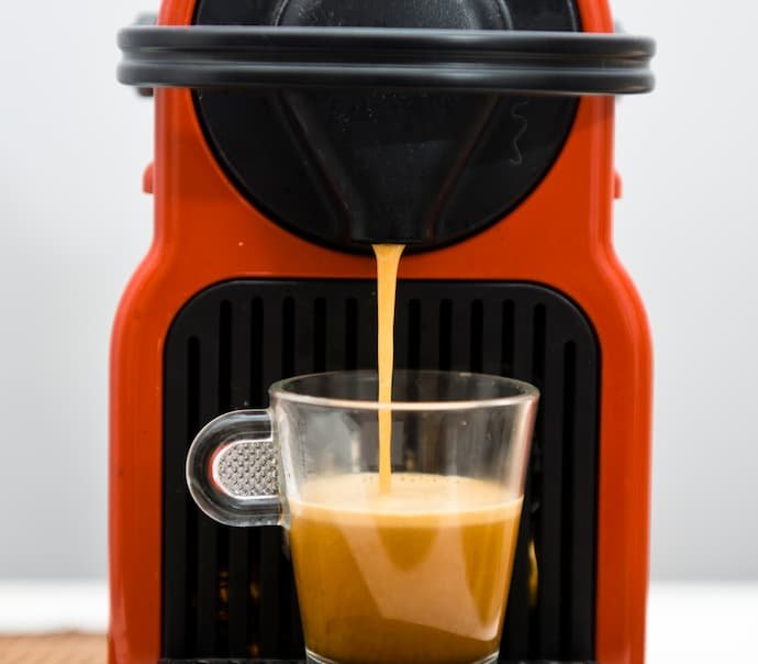 Uma melhor cafeteira Dolce Gusto enchendo uma caneca de café.