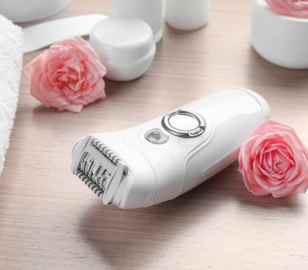 Um dos melhores depiladores elétricos ao lado de uma rosa.