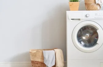 Uma máquina lava e seca ao lado de um cesto de roupas.