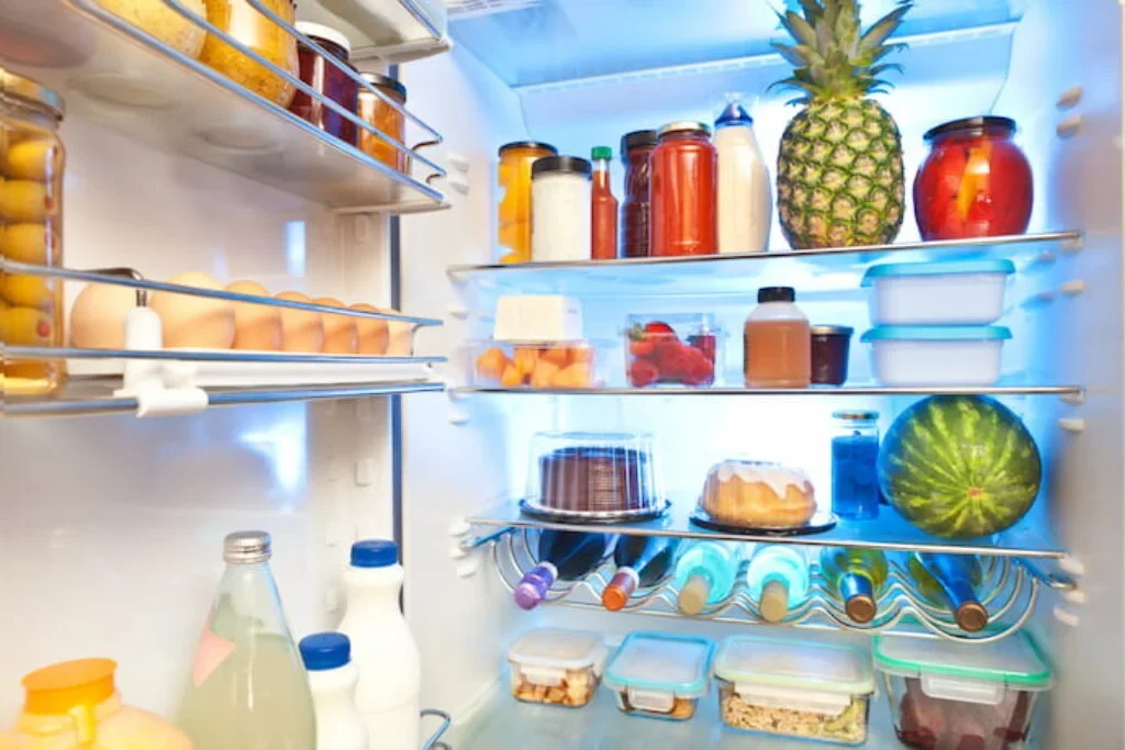 Uma geladeira aberta repleta de comidas e bebidas.
