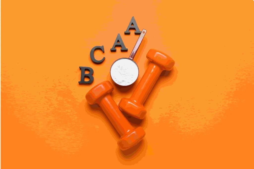 Dois halteres, um scoop e "BCAA" escrito em fundo laranja.
