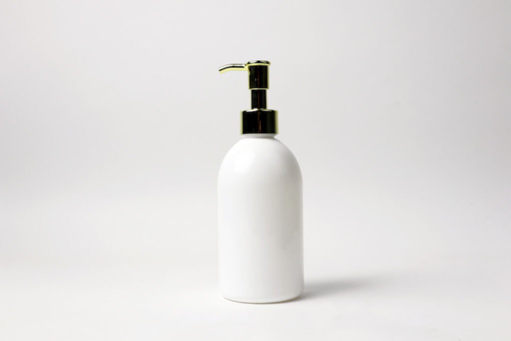 Pote branco de shampoo em um fundo branco.