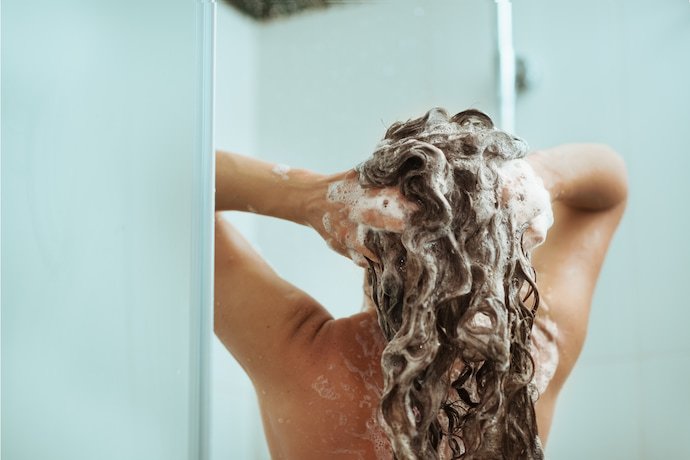 Mulher enxaguando o cabelo.
