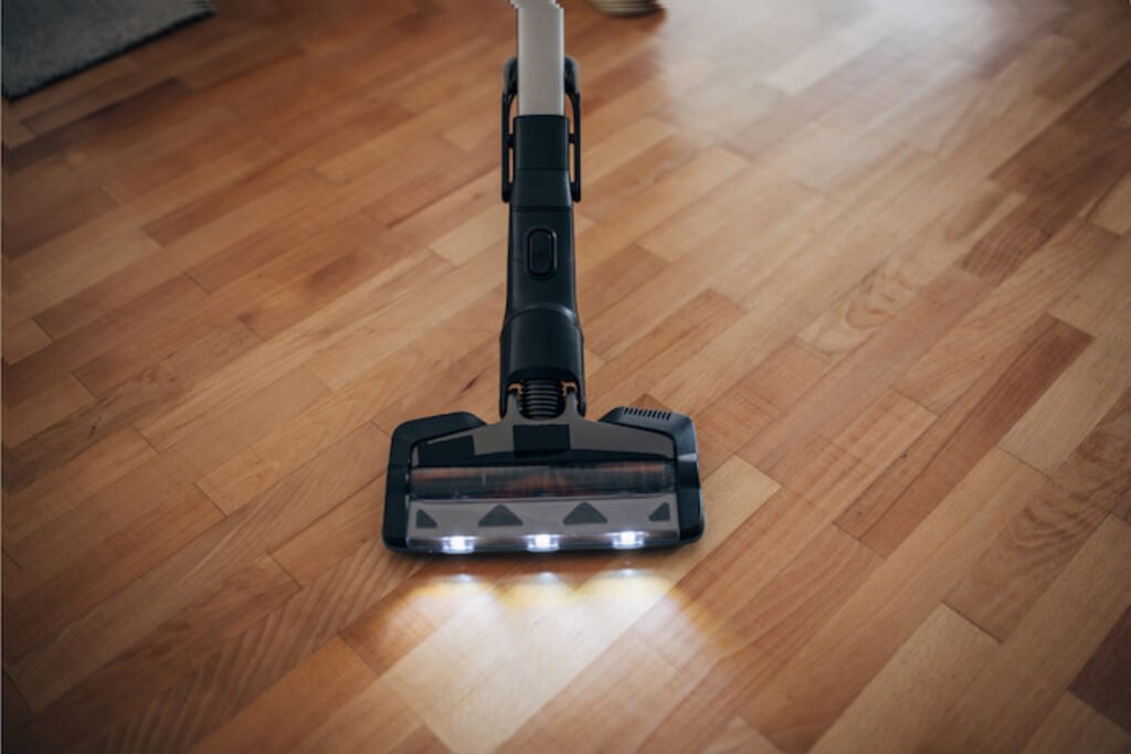 Aspirador com iluminação LED em um chão de taco.