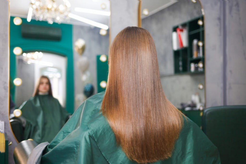 Mulher loira de cabelo liso olhando no espelho.