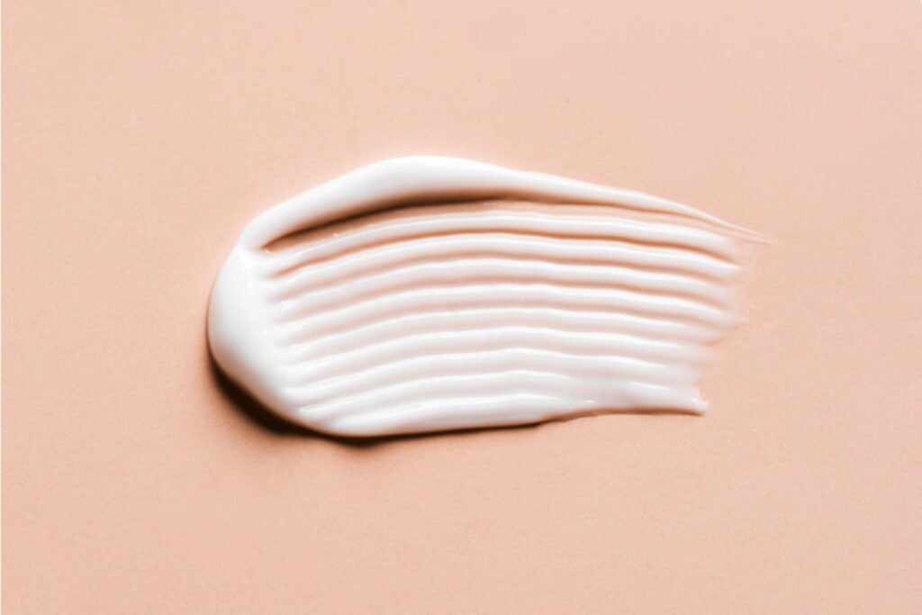 Rastro de creme em um fundo rosa.