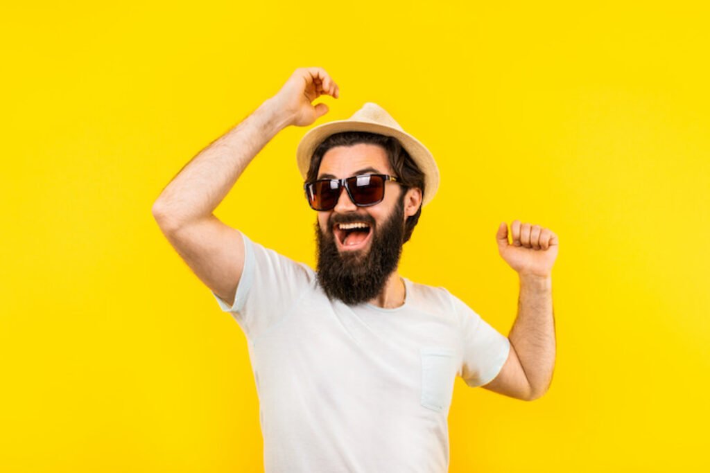 Homem de barba e óculos em um fundo amarelo.