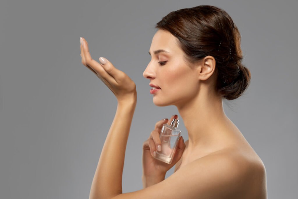 Mulher sentindo o cheiro de um perfume.