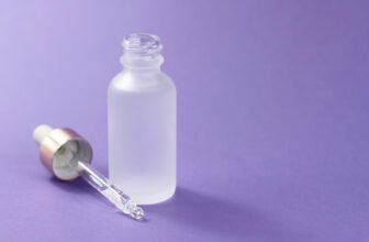 Frasco de ácido hialurônico em um fundo roxo.