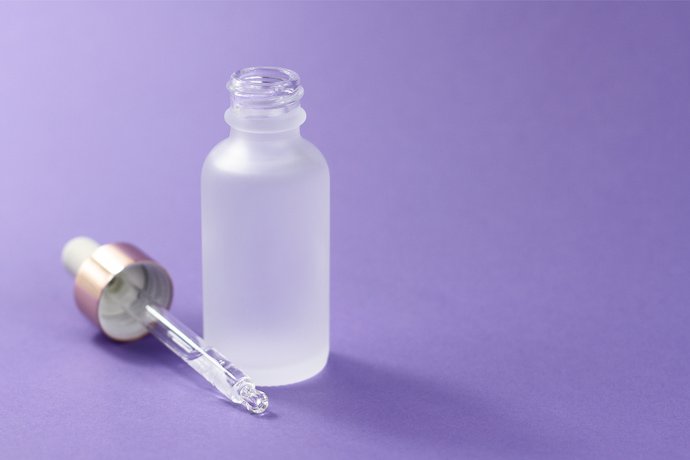 Frasco de ácido hialurônico em um fundo roxo.