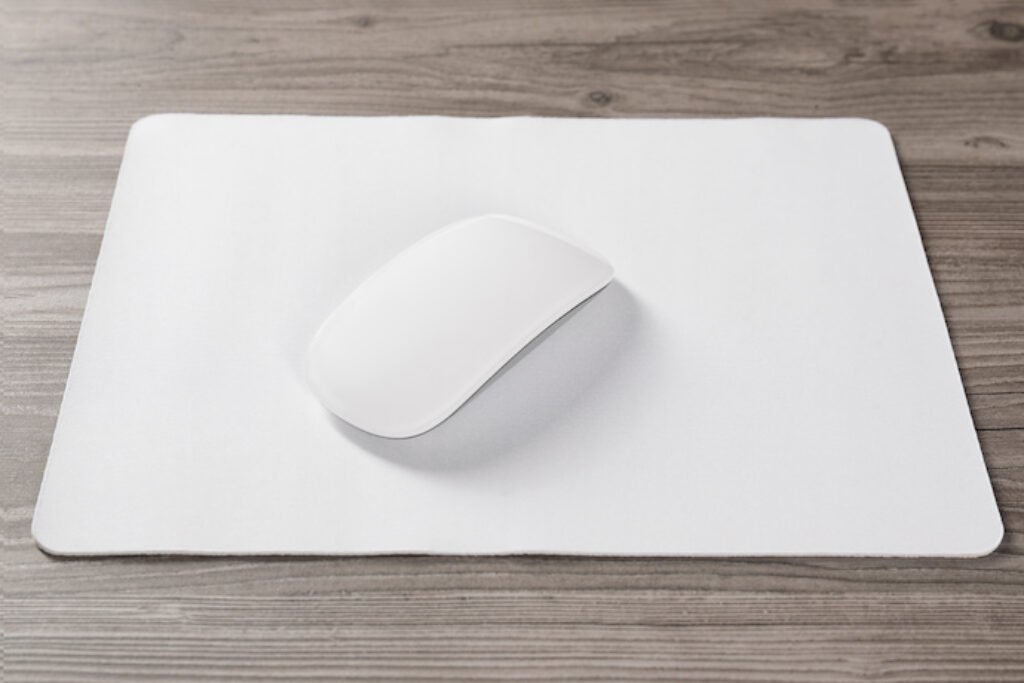 Mouse sem fio branco em um mousepad branco.