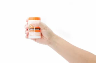 Mulher segurando um pote de vitamina C.