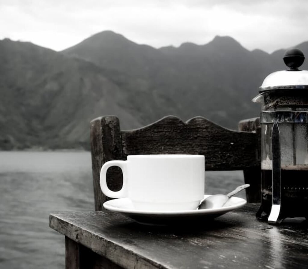 Uma mesa com café em um cenário natural com serras.