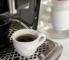 Uma xícara cheia de café na bandeja de uma melhor cafeteira custo-benefício.