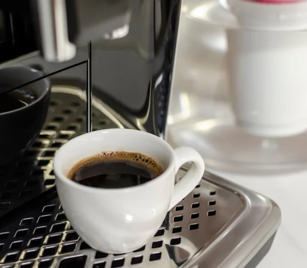 Uma xícara cheia de café na bandeja de uma melhor cafeteira custo-benefício.