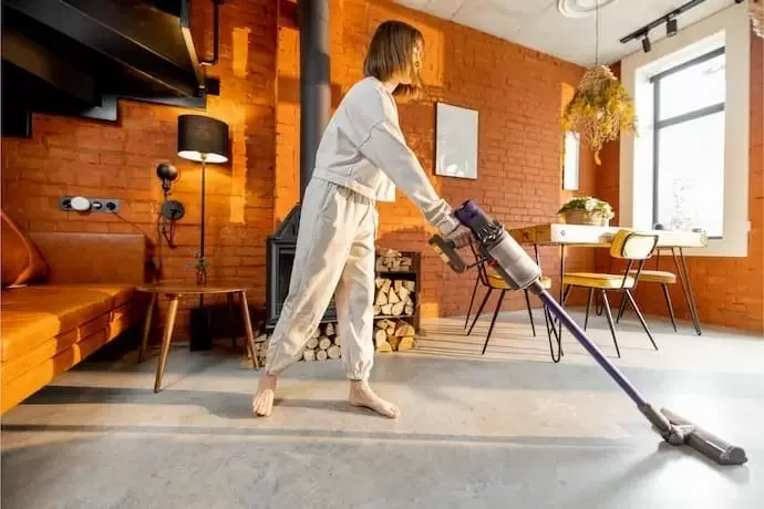 Mulher aspirando o chão.