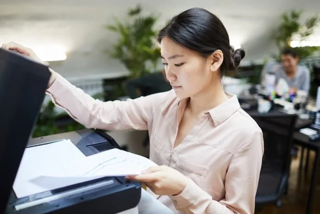 Uma mulher colocando um documento na impressoa Epson para digitalizar,