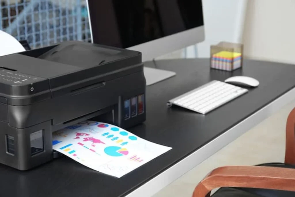 Uma impressora Epson em cima de uma mesa de escrtório imprimindo alguns gráficos.