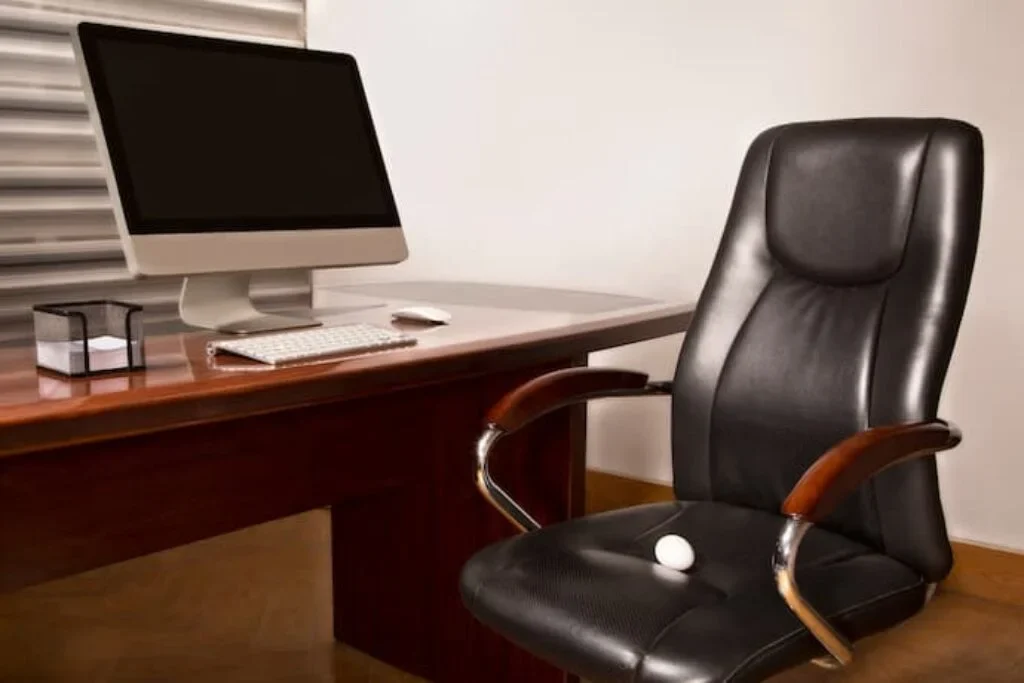 Uma cadeira home office na frente de uma mesa de computador.