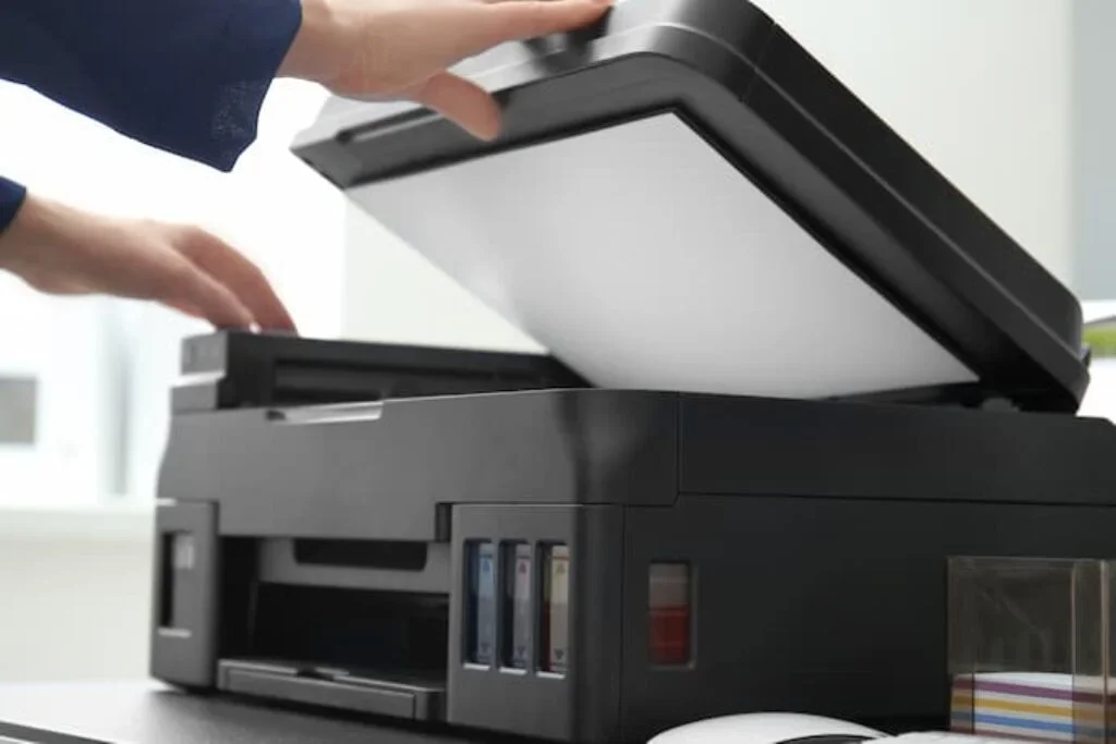 Uma pessoa abrindo a tampa de scanner de uma impressora Epson.