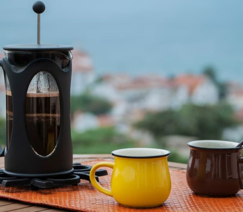 Uma prensa francesa e duas canecas de cafés.