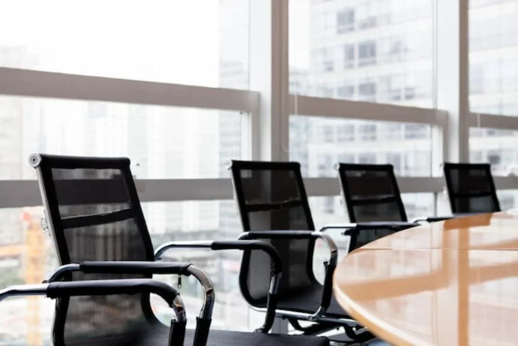 Diversas cadeiras ergonômicas em uma sala de reunião.