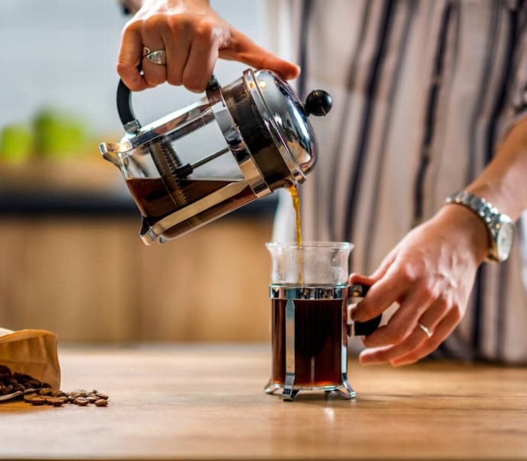 Uma pessoa servindo café direto da prensa francesa.